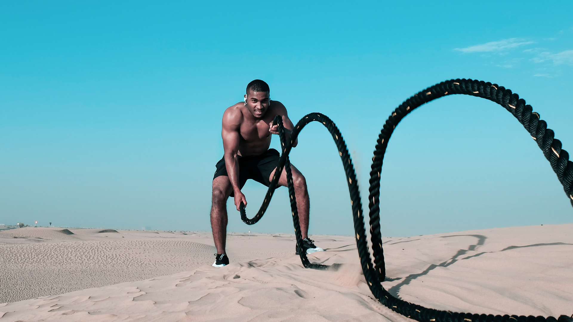 Man training on battle ropes.